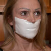 Mature blonde woman gagged with shiny white microfoam tape stretched across her mouth, eyes looking sideways